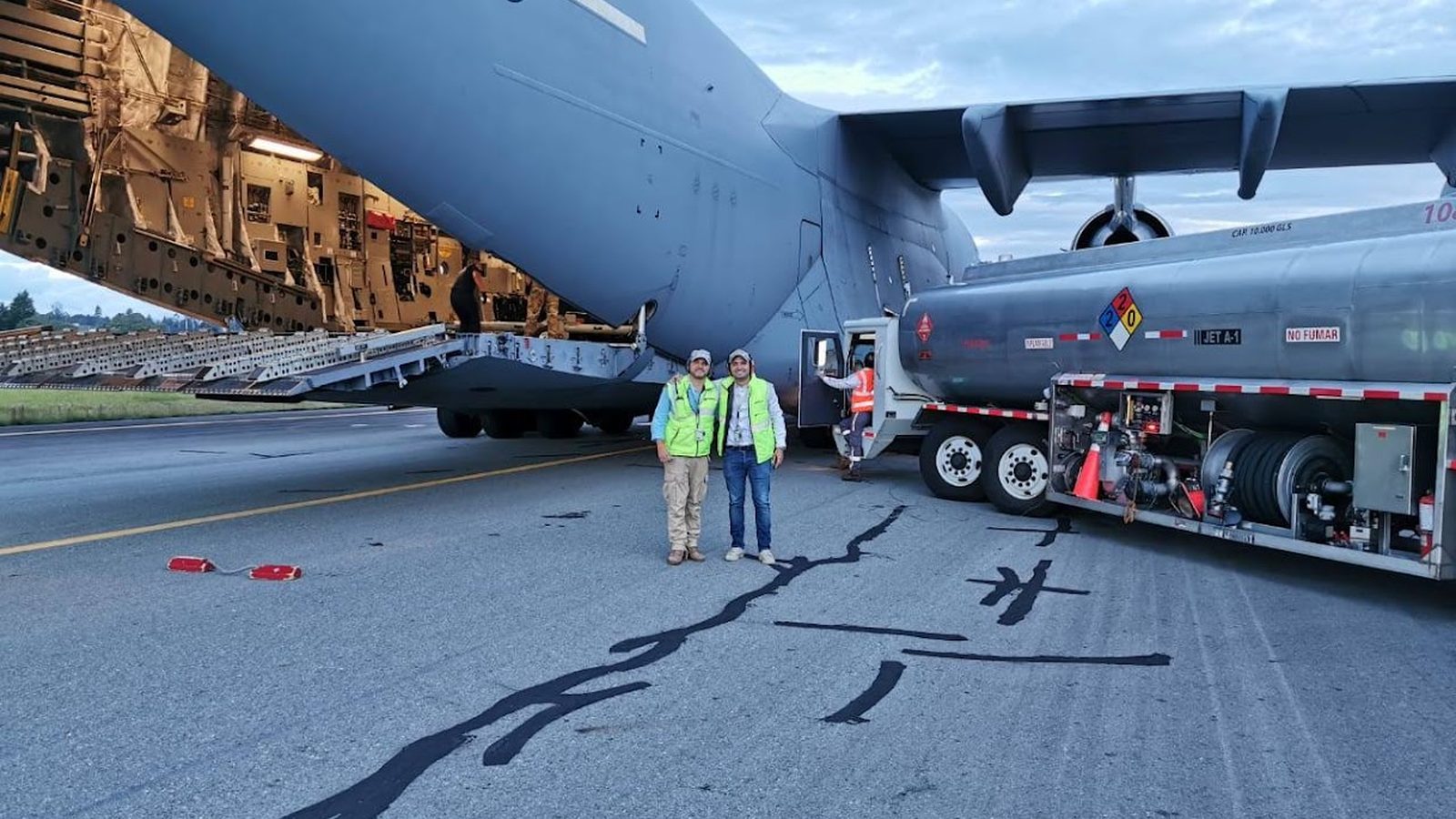 Ground crew loading military cargo onto a transport aircraft ramp