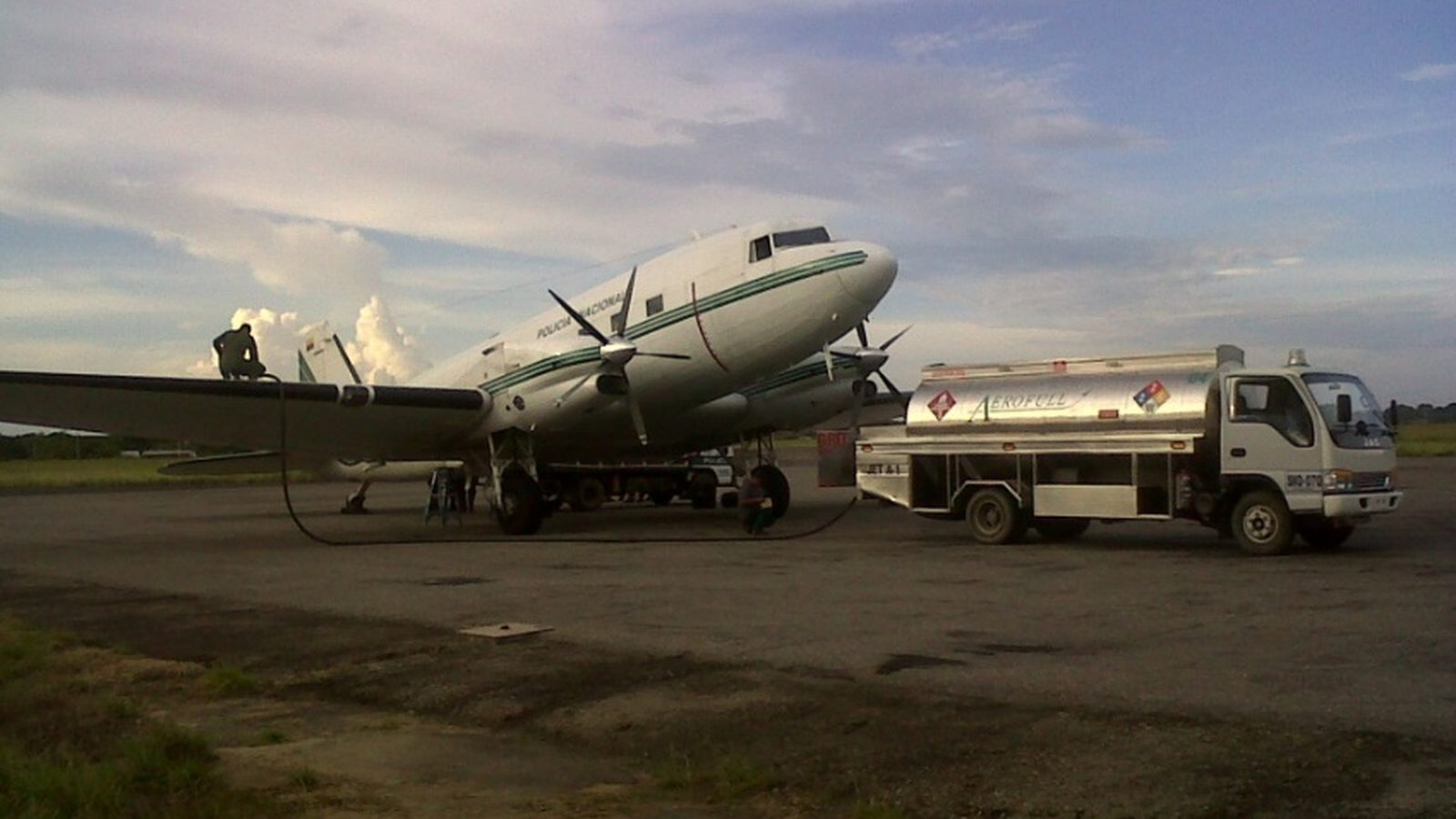 Aerofull fuel truck refueling a DC-3 aircraft at dusk