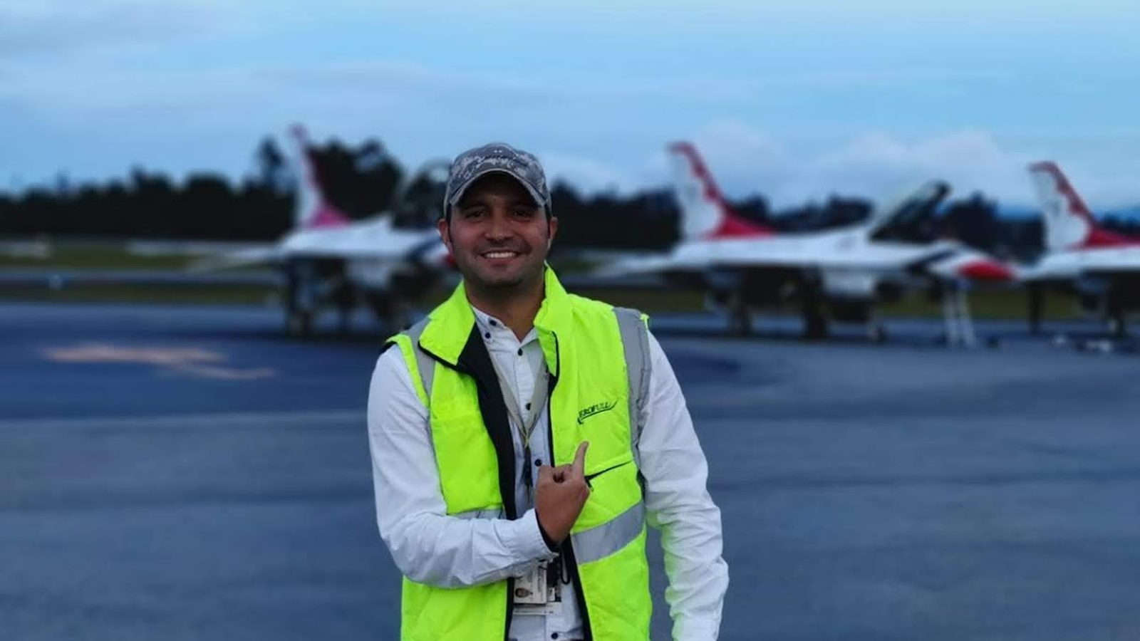 Aerofull crew member on the flight line beside a fighter jet