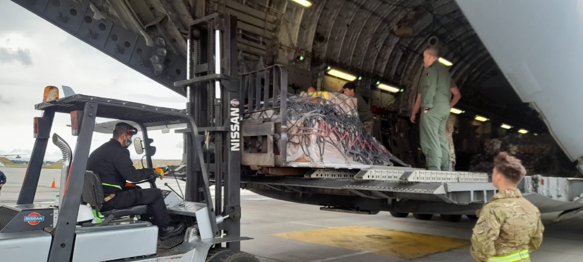 Ground handling crew loading cargo onto a military aircraft with a forklift