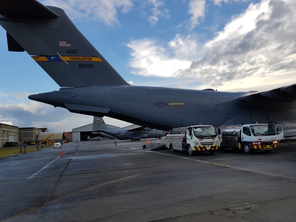 Military transport aircraft on the ramp with ground service vehicles